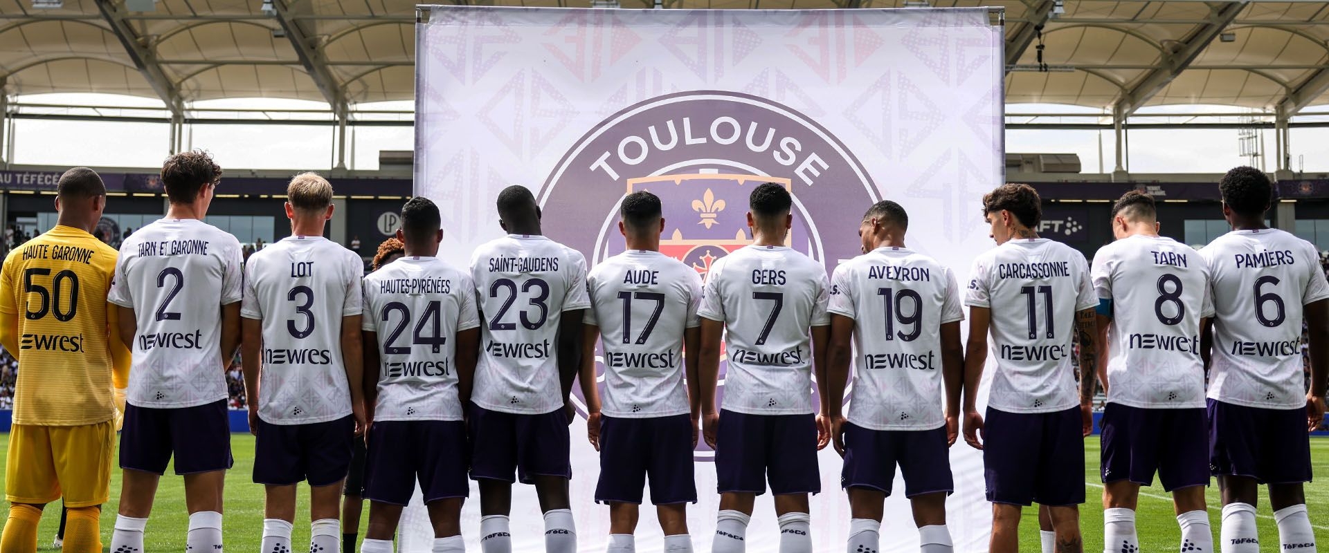 Bandeau -  joueurs de dos avec les maillot floqués aux noms de villes et départements- Le maillot Heard - Toulouse Football Club